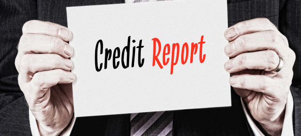 A man in a suit holding a white card that says credit report